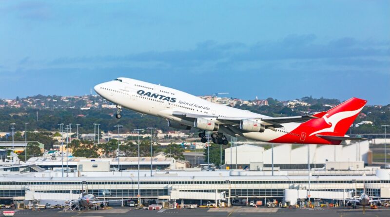 a Qantas 747 taking off from Sydney airport with the terminal building in the background.