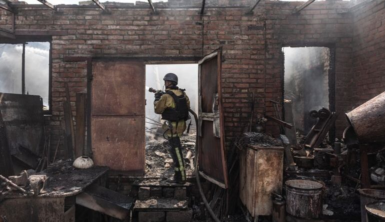 a firefighter stands in a burnout out building
