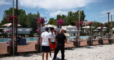 Workers stand near the swimming pool of the 'Le Mimose' resort, where skydiver Felix Baumgartner's paraglider crashed, killing him and injuring a hotel employee on the ground, in Porto Sant'Elpidio, Italy