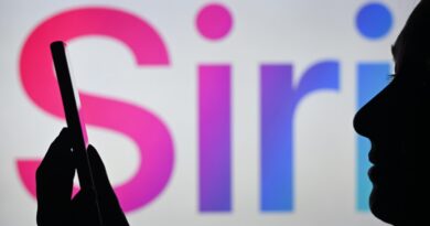 An image of a woman holding a cell phone in front of the Siri logo displayed on a computer screen.