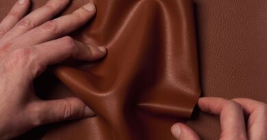 Two hands crumple Uncaged Innovations' artificial leather.