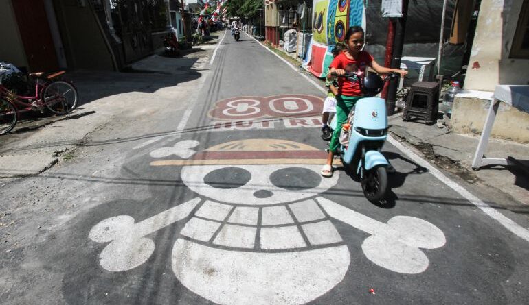 A graffiti of the pirate flag from Japanese anime One Piece, adopted by some Indonesians as a symbol of frustration with their government, is seen on a street in Sukoharjo, Central Java, on August 6, 2025, ahead of the countrys 80th Independence Day. As Indonesia's independence day approaches red and white flags will be flown across the country, but a viral anime pirate banner has drawn government threats against flying the swashbuckling ensign. A Jolly Roger skull and bone symbol topped with a straw hat from Japan's anime series 'One Piece' has caused concern among officials in Jakarta that it is being used to criticise President Prabowo Subianto's policies. (Photo by DIKA / AFP) / TO GO WITH 'INDONESIA-POLITICS-PROTEST-ANIME, FOCUS' BY DESSY SAGITA & JACK MOORE