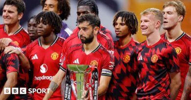 Manchester United players stand next to the Premier League Summer Series trophy