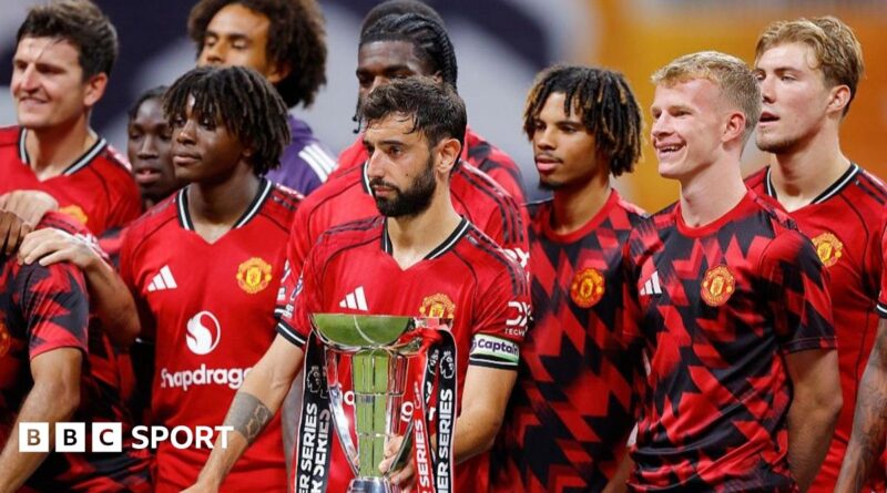 Manchester United players stand next to the Premier League Summer Series trophy