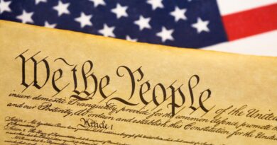 a photo of the US Constitution next to a US flag