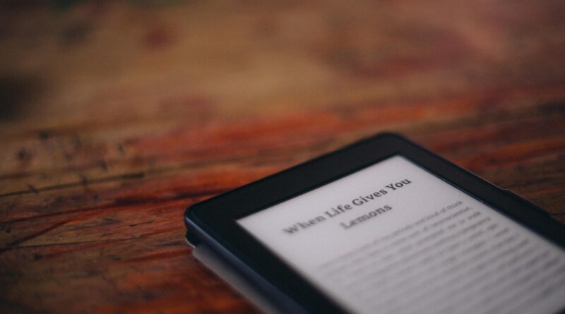 Amazon Kindle e-reader laying on a wooden surface