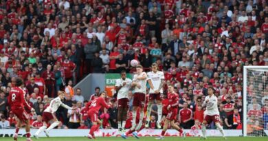 Liverpool's Hungarian midfielder #08 Dominik Szoboszlai (L) strikes the ball over the wall from a free kick to score the opening goal during the English Premier League football match between Liverpool and Arsenal