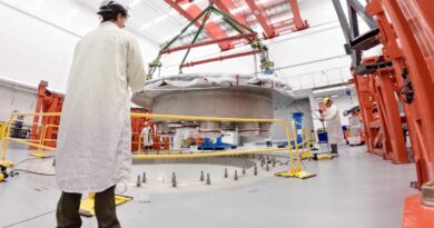 Commonwealth Fusion Systems employees supervise the installation of the tokamak's cryostat base.