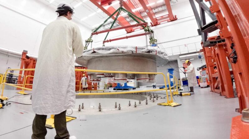Commonwealth Fusion Systems employees supervise the installation of the tokamak's cryostat base.