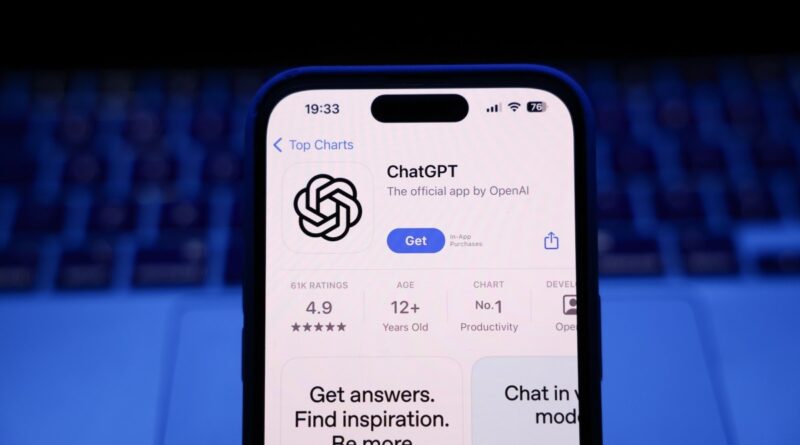 A laptop keyboard and ChatGPT on App Store displayed on a phone screen.