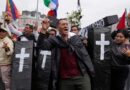 Protesters hold up model coffins to represent the dead.
