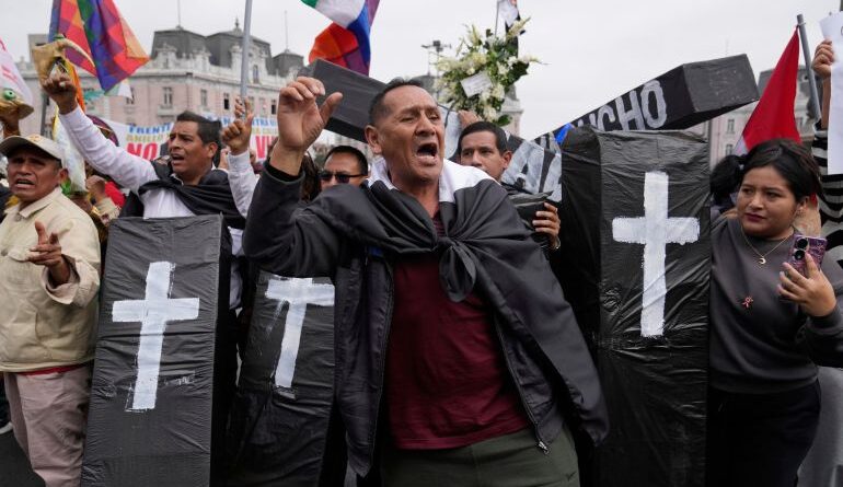 Protesters hold up model coffins to represent the dead.