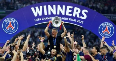 Paris Saint-Germain coach Luis Enrique lifts the trophy as he celebrates with his players after winning the Champions League