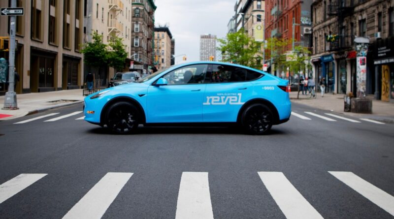 Light blue Revel rideshare mid-street