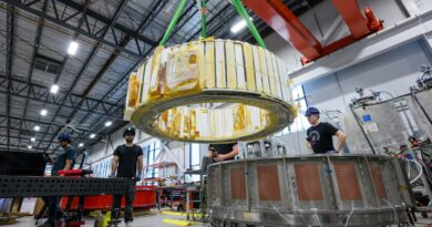 Engineers watch as a magnet is moved inside Commonwealth Fusion System's building.