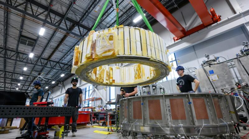 Engineers watch as a magnet is moved inside Commonwealth Fusion System's building.