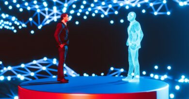 Man standing on a red platform, facing a holographic digital twin of himself. The background features a network of interconnected blue lights, creating a futuristic and high-tech atmosphere. The scene represents concepts of digital twins, virtual reality, and advanced technology.