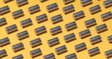 A large group of batteries laid in a pattern on a yellow background
