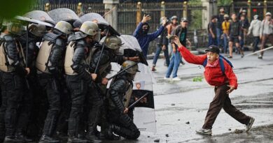 A protester throws rock at riot police officers during a protest against lavish allowances given to parliament members, in Jakarta, Indonesia, Thursday, Aug. 28, 2025. (AP Photo/Achmad Ibrahim)
