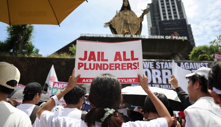 Protesters hold signs during a rally against the government corruption at the historic EDSA Shrine in suburban Mandaluyong, east of Manila, Philippines, Sunday. Sept. 21, 2025. (AP Photo/Basilio Sepe)