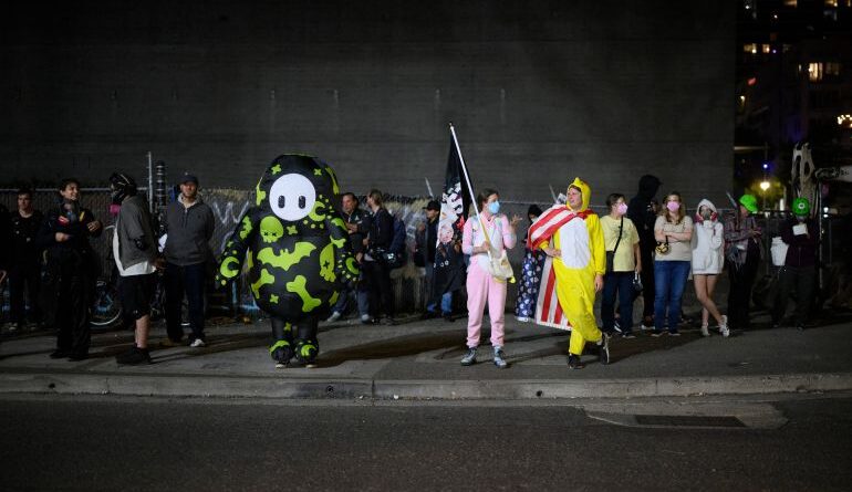 PORTLAND, OREGON - SEPTEMBER 27: Protesters stand outside the U.S. Immigration and Customs Enforcement building on September 27, 2025 in Portland, Oregon. In a Truth Social post, President Trump authorized the deployment of military troops to "protect War ravaged Portland, and any of our ICE Facilities under siege from attack by Antifa, and other domestic terrorists." Mathieu Lewis-Rolland/Getty Images/AFP (Photo by Mathieu Lewis-Rolland / GETTY IMAGES NORTH AMERICA / Getty Images via AFP)