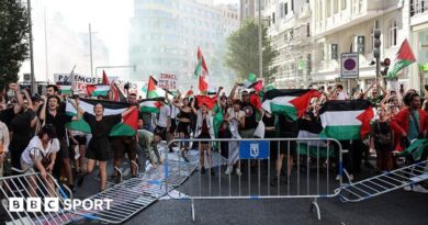 Pro-Palestinian protesters in the middle of the road next to overturned barriers