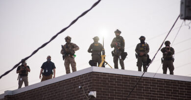 U.S. Immigration and Customs Enforcement (ICE) agents, Department of Homeland Security (DHS) personnel, and Border Patrol Commander Gregory Bovino stand together amidst a tense protest outside the ICE processing facility in Broadview, Illinois, on September 27, 2025.