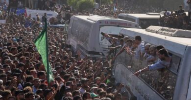 People gather to greet freed Palestinian prisoners arriving on buses in the Gaza Strip after their release from Israeli jails under a ceasefire agreement between Hamas and Israel, outside Nasser Hospital in Khan Younis, southern Gaza Strip, Monday, Oct. 13, 2025. (AP Photo/Jehad Alshrafi)