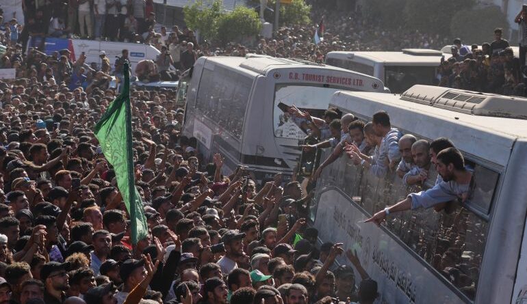 People gather to greet freed Palestinian prisoners arriving on buses in the Gaza Strip after their release from Israeli jails under a ceasefire agreement between Hamas and Israel, outside Nasser Hospital in Khan Younis, southern Gaza Strip, Monday, Oct. 13, 2025. (AP Photo/Jehad Alshrafi)