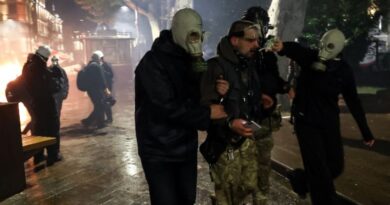 A protester receives help after being hit by tear gas during clashes with riot police during an opposition rally on the day of local elections in central Tbilisi on October 4, 2025. [Giorgi Arjevanidze/AFP]