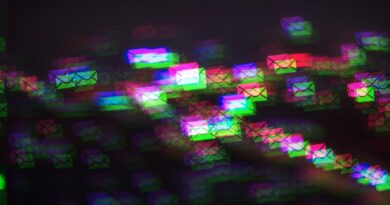 a pattern of multicolored photo-moshed envelopes flowing across on a dark background