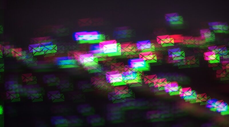 a pattern of multicolored photo-moshed envelopes flowing across on a dark background