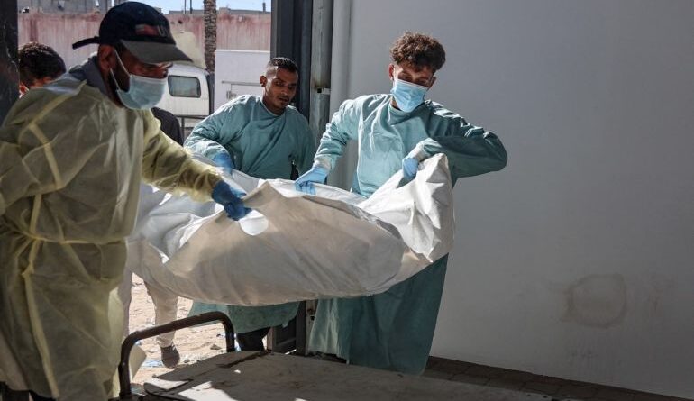 Hospital workers transport the remains of a Palestinian released by Israel under a Gaza ceasefire and hostage exchange deal, to the morgue of Nasser hospital in Khan Yunis in the southern Gaza Strip, on October 18, 2025. Israel returned the bodies of 15 Palestinians to Gaza on October 18, bringing the total number handed over to 135, the health ministry in the Hamas-run territory said.