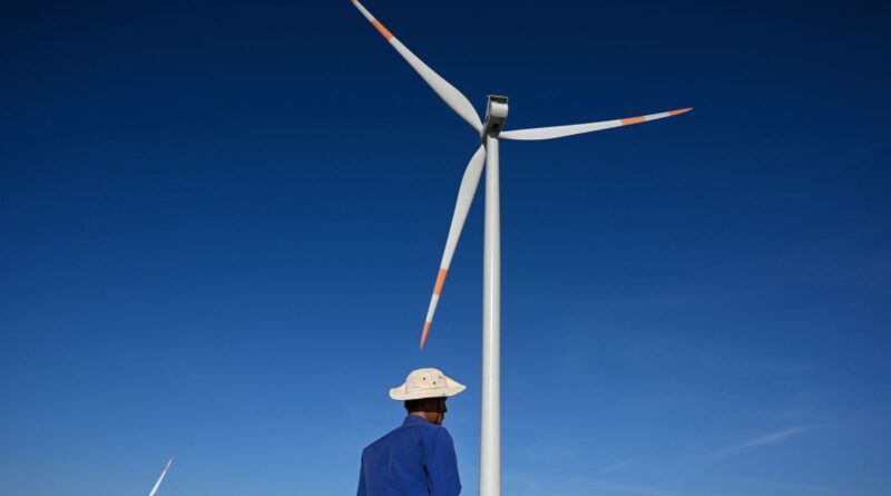 A man in front of a wind turbine in Vietnam