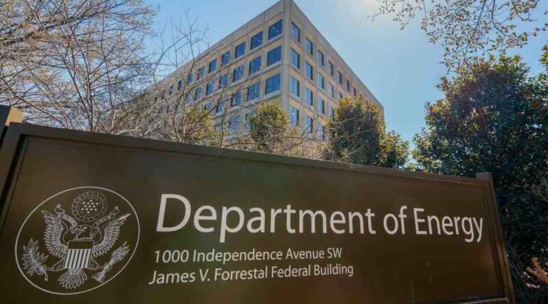 The U.S. Department of Energy building is seen behind a sign marking the location of the agency's headquarters.
