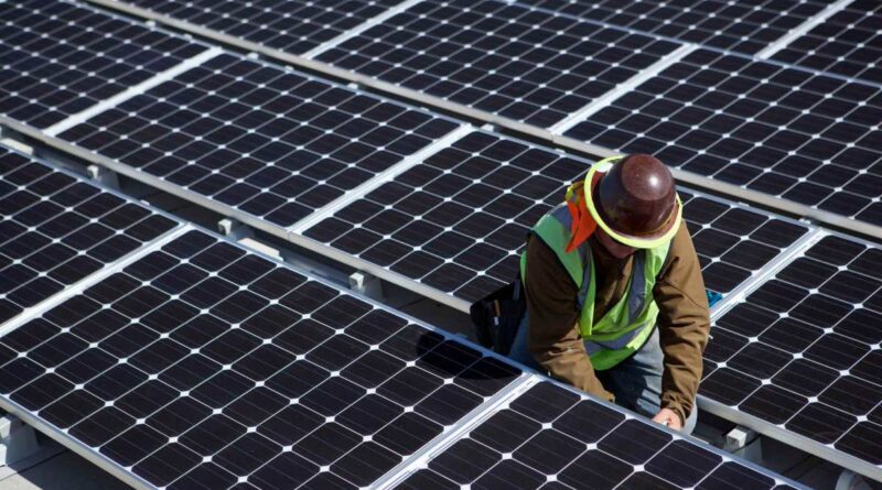 A man inspects solar panels.