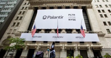 A mail carrier wearing a protective mask passes a banner displaying Palantir Technologies Inc. signage during the company's initial public offering (IPO) in front of the New York Stock Exchange (NYSE) in New York, U.S., on Wednesday, Sept. 30, 2020.