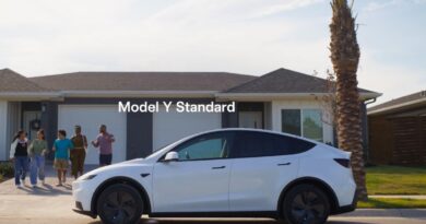 white Tesla Model Y parked in front of a house