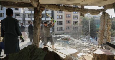 Residents remove debris from a house damaged by attacks.