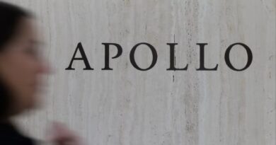 Apollo Global Management signage on a marble wall, with a blurred person passing in the foreground.
