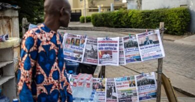 A vendor looks at newspapers displayed on a stall in Cotonou, on December 08, 2025.