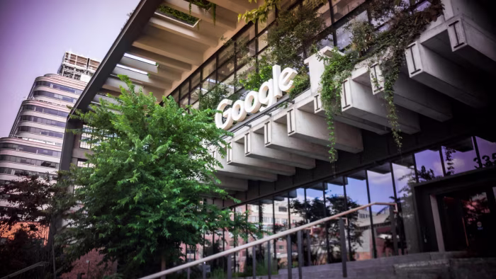 The Google logo on the exterior of the renovated St. John’s Terminal, with greenery hanging from the building.