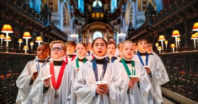 St Paul’s Cathedral choristers in white robes holding candles and singing during Christmas rehearsals inside the cathedral.