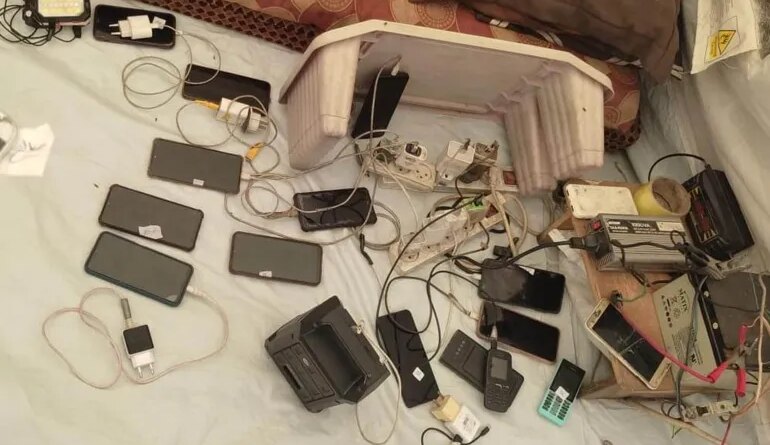 a photo of a dozen phones charging