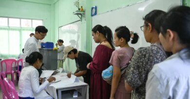People line up to vote inside a polling station during the first phase of Myanmar's general election in Yangon on December 28, 2025.Polling opened in Myanmar's heavily restricted junta-run elections, beginning a month-long vote democracy watchdogs describe as a rebranding of military rule.