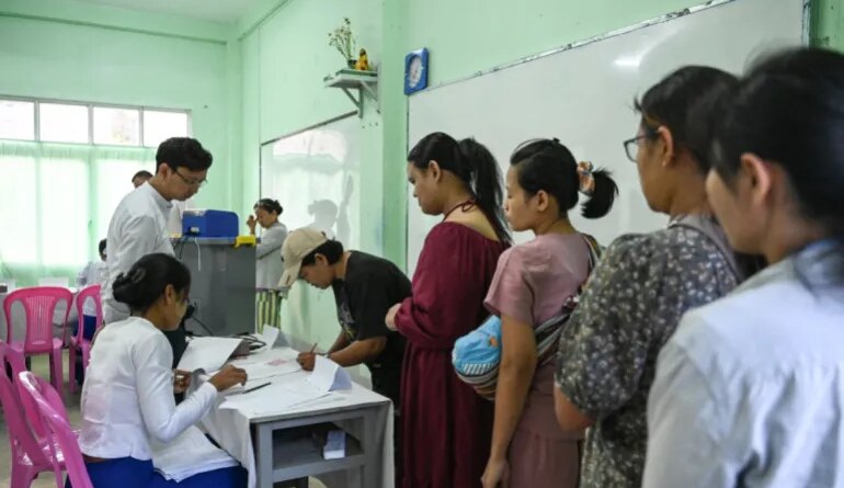 People line up to vote inside a polling station during the first phase of Myanmar's general election in Yangon on December 28, 2025.Polling opened in Myanmar's heavily restricted junta-run elections, beginning a month-long vote democracy watchdogs describe as a rebranding of military rule.