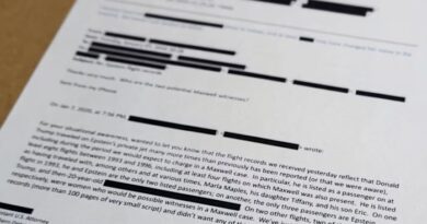 A printed email with numerous redactions is shown close up; the text discusses Jeffrey Epstein and related flight records