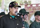 Nicolas Maduro, wearing a military uniform and cap, speaks into a microphone during an event with Venezuelan military personnel.