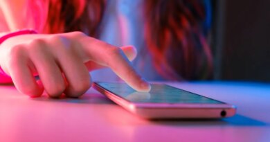person touching a smartphone laying on a table.
