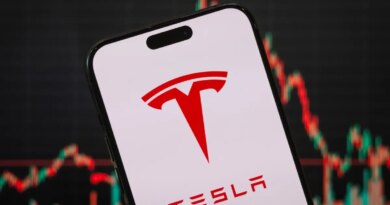 In this photo illustration, the Tesla logo is displayed on a smartphone screen
